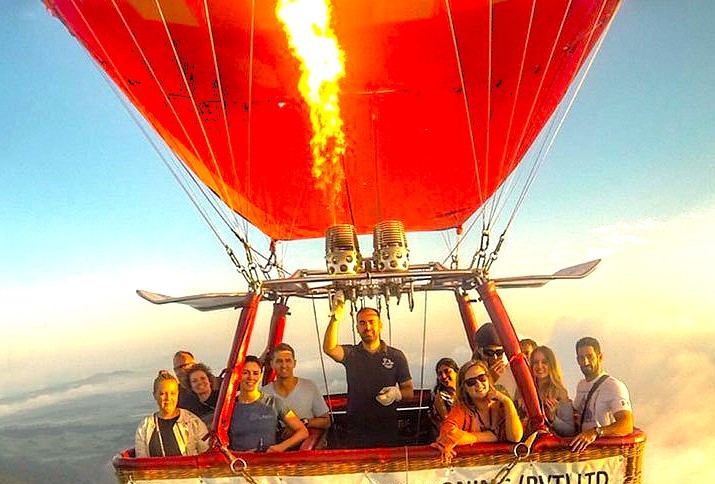 Tourists enjoy the exhilarating ride high above the clouds in the basket of a Hot Air Ballooning Srinagar flight, a memorable adventure near Nigeen Lake and the Nehru Ghat shikara boat tour in Jammu and Kashmir, India.