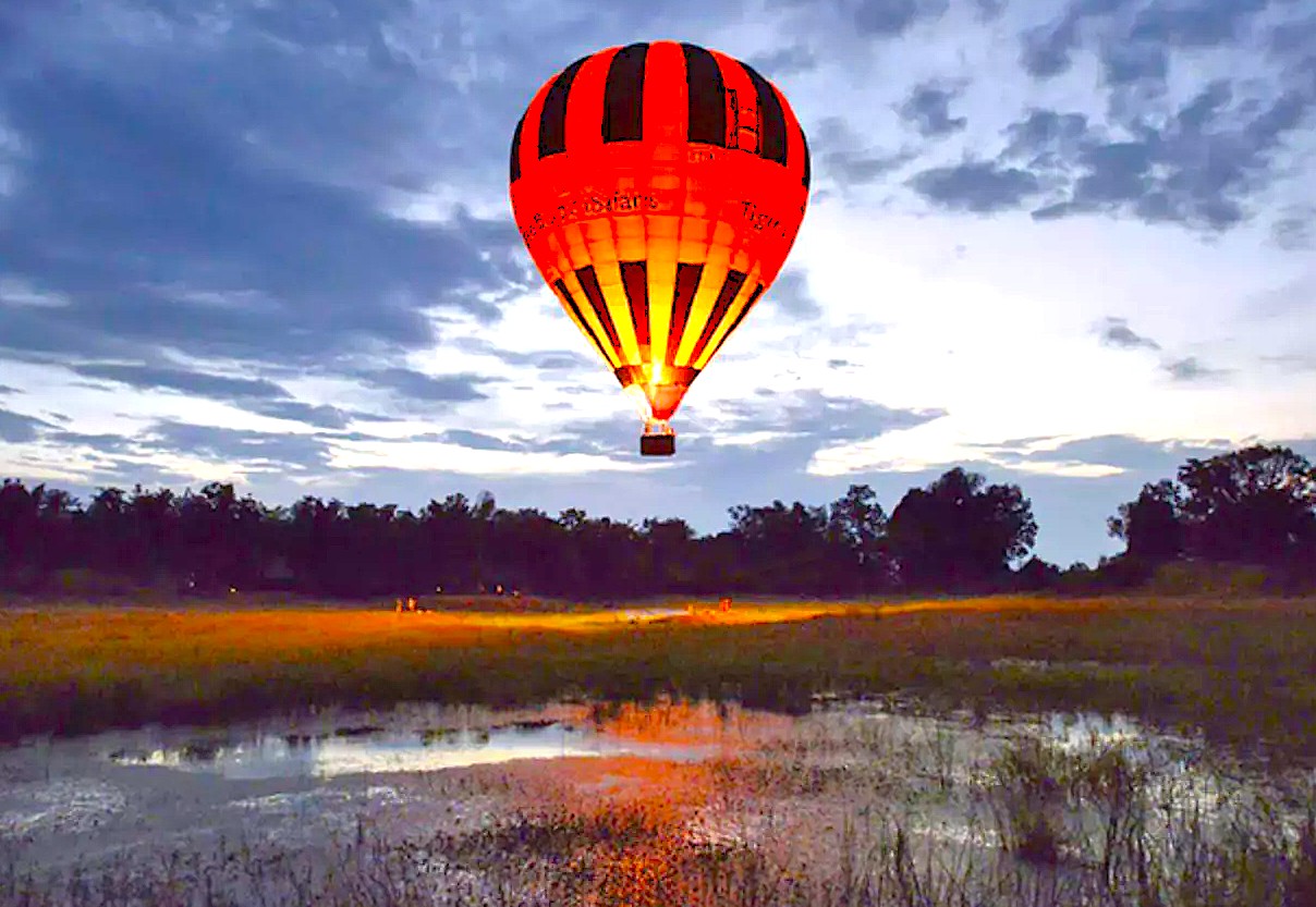 Hot air ballooning over serene landscapes near Mysore, Karnataka, India, offering stunning panoramic views, reflective wetlands, sunrise adventure, cultural heritage insights, and unforgettable travel experiences.