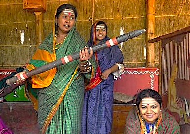 Women in traditional attire perform a cultural demonstration at Agadi Thota Village in Hubli, Karnataka, India, a popular stop for tourists on the way to Old Goa Unesco churches.
