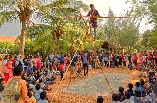 A performer entertains schoolchildren at Agadi Thota Village in Hubli, Karnataka, India, a popular cultural stop for tourists on the way to the Old Goa Unesco churches.