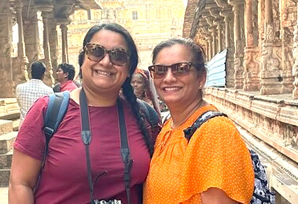Two smiling female tourists pose for a photo while exploring the intricately carved stone temples of Badami, Karnataka, India. This historic heritage town, home to the sacred Agastya Lake, is a popular travel destination located near the Pattadakal UNESCO World Heritage site. Two smiling female tourists pose for a photo while exploring the intricately carved stone temples of Badami, Karnataka, India. This historic heritage town, home to the sacred Agastya Lake, is a popular travel destination located near the Pattadakal UNESCO World Heritage site.