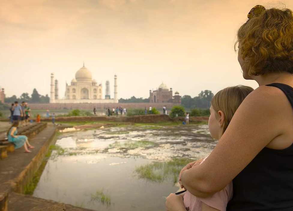 Tourists in Agra, India on your way to Taj Mahal pause by reflective pools at the UNESCO Heritage site, admiring Mughal architecture, lush gardens, serene ambiance and white marble splendor. Tourists in Agra, India on your way to Taj Mahal pause by reflective pools at the UNESCO Heritage site, admiring Mughal architecture, lush gardens, serene ambiance and white marble splendor.