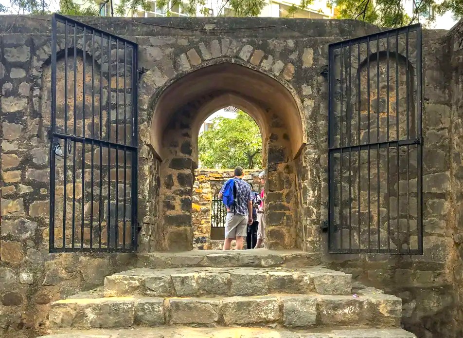 Historic India-Agrasen Ki Baoli New Delhi invites exploration through its ancient stone archway and iron gates, revealing majestic stepwell architecture, serene timeless heritage atmosphere, and a peaceful hidden urban sanctuary.