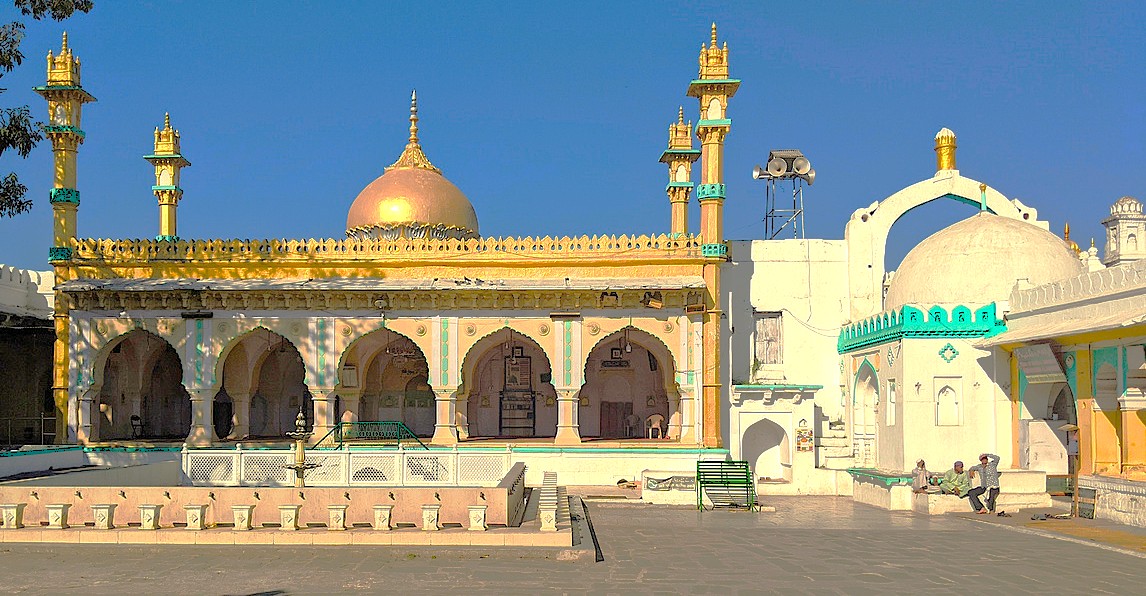 Historic Alamgir Dargah mosque in Aurangabad, Maharashtra, India, near UNESCO Ellora and Ajanta Caves, features golden domes, slender minarets, arched portico, open courtyard and vibrant Islamic stone carvings welcoming visitors.