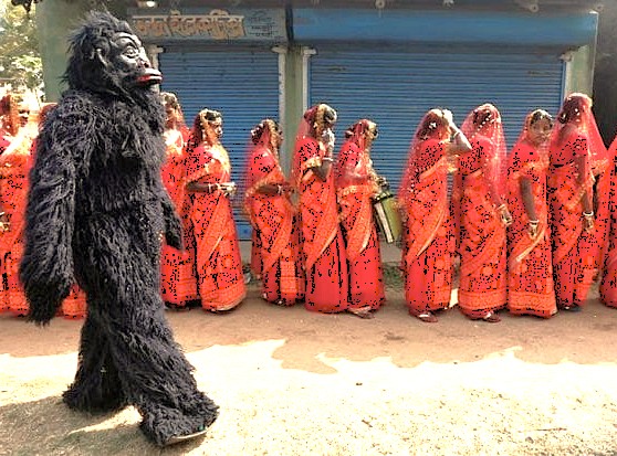 A vibrant community celebration with costumed performers takes place near Anegundi Fort in Karnataka, India, reflecting the lively local culture. This area is part of the Hampi UNESCO site, a region famous for its historical wonders like the Queen's Baths, Vittala Temple, and the Elephant Stables.