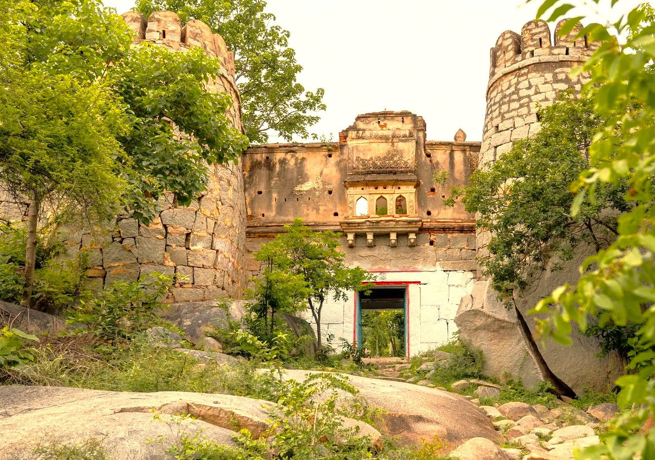 The ancient stone entrance of Anegundi Fort in Karnataka, India, invites exploration into the history of the Hampi UNESCO site, a region renowned for its architectural marvels including the Queen's Baths, the magnificent Vittala Temple, and the grand Elephant Stables.