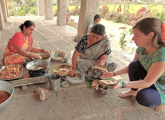 Sharing a traditional meal prepared by local women within Anegundi Fort in Karnataka, India, offers an authentic cultural experience. This historic fort is part of the Hampi UNESCO site, a region celebrated for architectural wonders like the Queen's Baths, Vittala Temple, and the grand Elephant Stables.