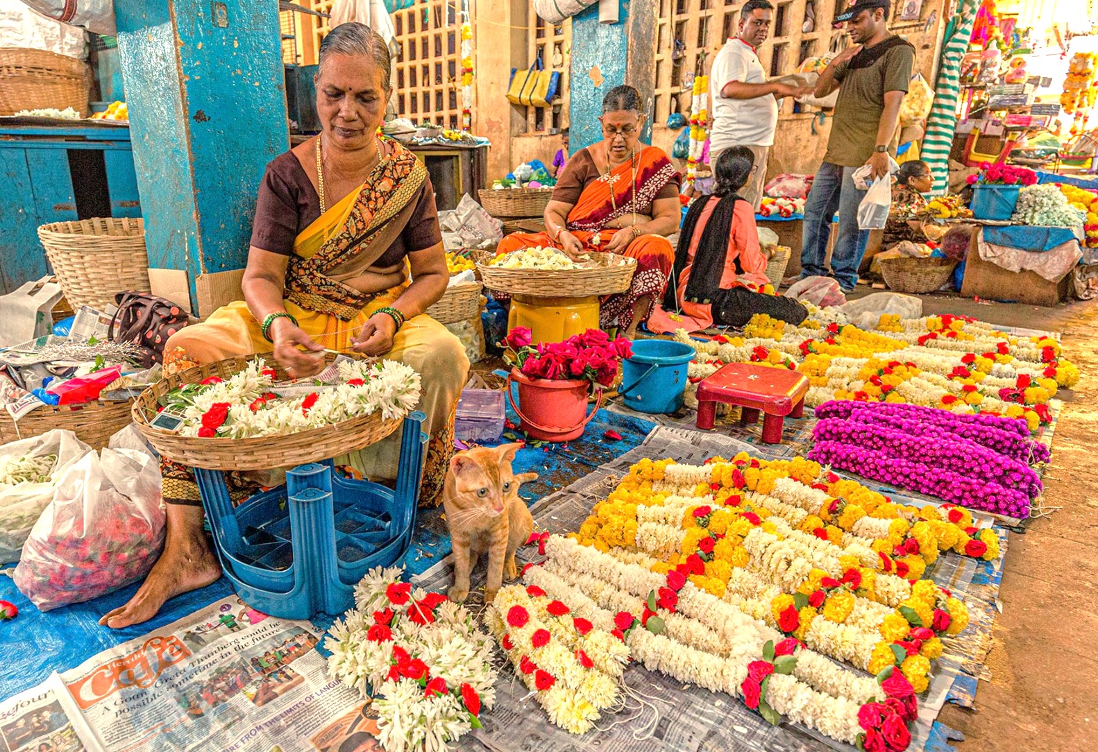 Local women sell vibrant flower garlands at a bustling stall, a common sight at the Anjuna Beach Flee Market in Goa, India, a region near Karnataka and the Old Goa St. Francis Church UNESCO churches. Local women sell vibrant flower garlands at a bustling stall, a common sight at the Anjuna Beach Flee Market in Goa, India, a region near Karnataka and the Old Goa St. Francis Church UNESCO churches.