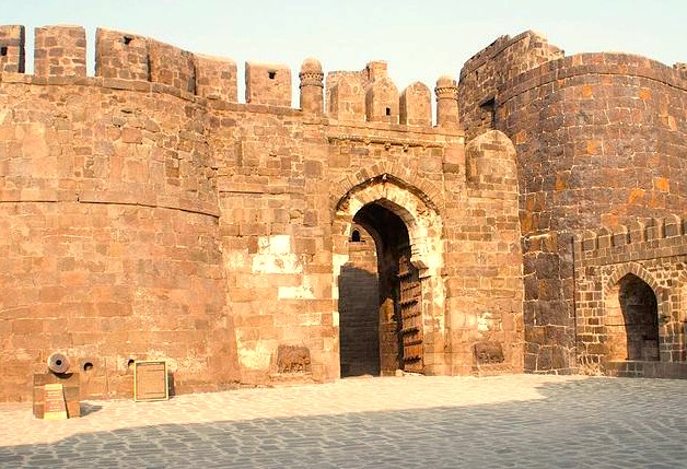 Massive magnificent medieval stone walls of Daulatabad Fort in Aurangabad, Maharashtra, stand sentinel overlooking the Mumbai–Aurangabad UNESCO railway journey to Elora and Ajanta Caves in India, showcasing historic defense architecture.