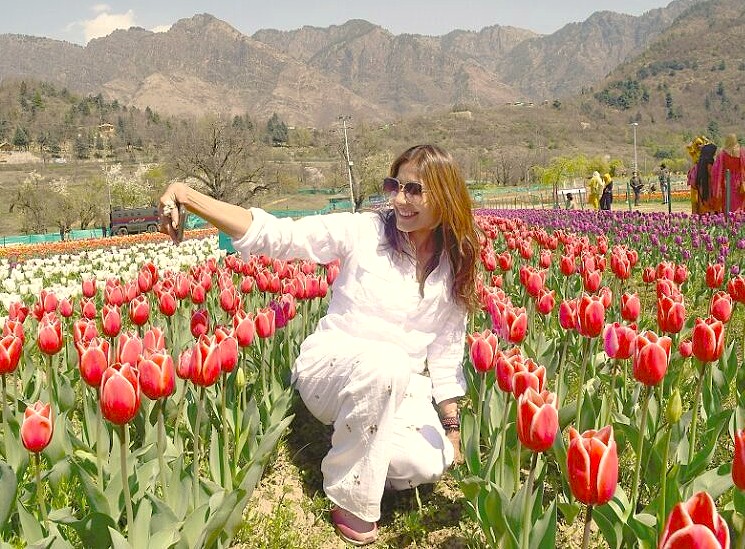 A tourist takes a selfie at the Tulip Garden festival in Srinagar, Jammu and Kashmir, a top attraction near saffron fields, Aru Valley, Betaab Valley, and Babu Arts and Craft Emporium.