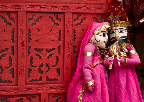 “Vibrant traditional Rajasthani puppets perform a cultural show against an ornate red backdrop at Bagore Ki Haveli in Udaipur, Rajasthan, India, showcasing folk artistry, festive ambiance, and rich heritage craftsmanship.”