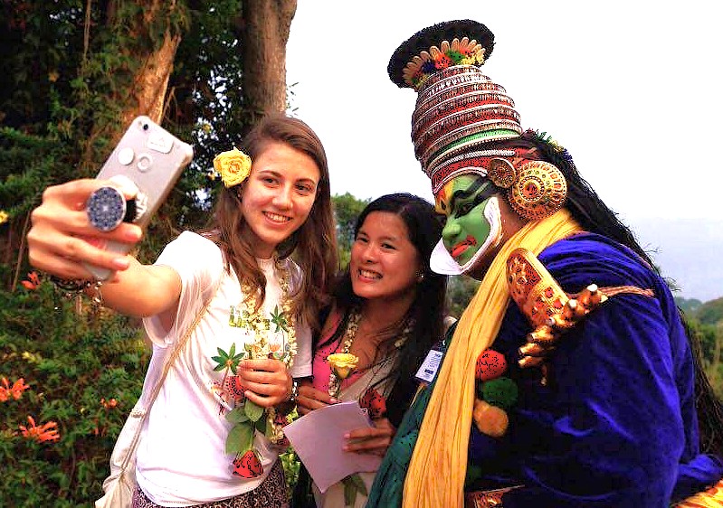 International visitors capture a memorable selfie with a traditional cultural performer in Udaipur, Rajasthan, India, a heritage city near Jaipur and Jodhpur, celebrated for its unique UNESCO-level cultural experiences.