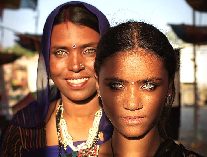 Two young Rajasthani women wearing traditional jewelry vibrant saris pose in front of Bhandasar Jain Temple in Bikaner, Rajasthan, India, near the expansive Thar Desert, showcasing cultural heritage and elegance. Two young Rajasthani women wearing traditional jewelry vibrant saris pose in front of Bhandasar Jain Temple in Bikaner, Rajasthan, India, near the expansive Thar Desert, showcasing cultural heritage and elegance.