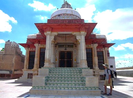 A traveler admires the majestic ornate pink marble Bhandasar Jain Temple in Bikaner, Rajasthan, India, set against the golden sands of the Thar Desert, showcasing historic architecture and spiritual heritage. A traveler admires the majestic ornate pink marble Bhandasar Jain Temple in Bikaner, Rajasthan, India, set against the golden sands of the Thar Desert, showcasing historic architecture and spiritual heritage.
