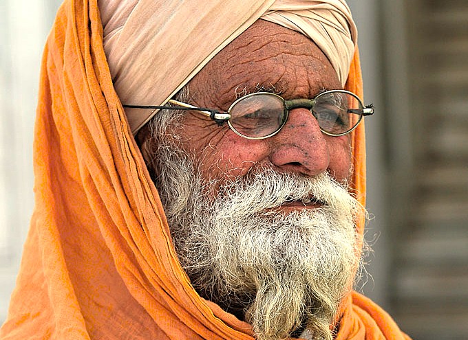 A portrait of an elderly Indian man in a traditional turban, representing the local culture seen by tourists visiting Old Goa Unesco churches like Bom Jesus Basilica in Goa, India.