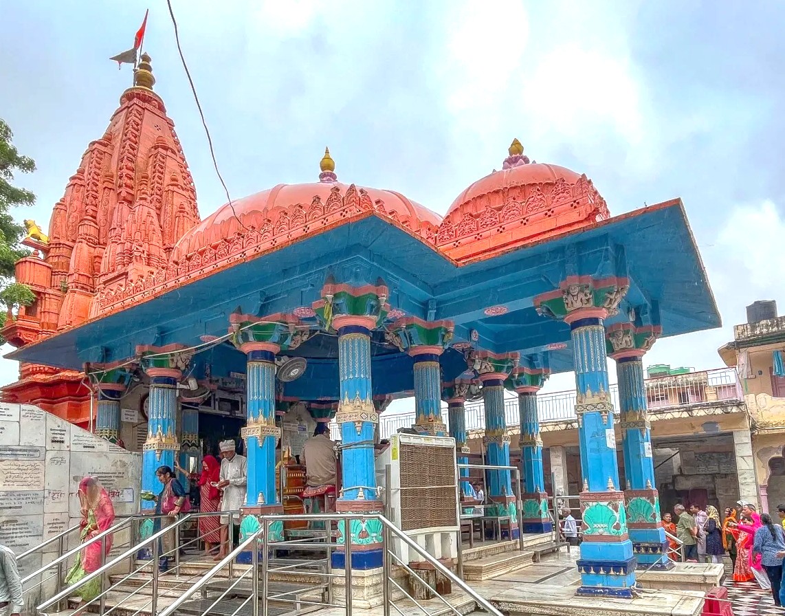 Vibrant Pushka-Brahma Temple in Rajasthan, India, showcases intricate red sandstone carvings and domes, drawing annual pilgrims traveling between Jaipur and Agra en route to the iconic Taj Mahal spiritual pilgrimage.