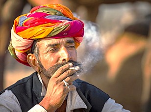 “Colorful Rajput elder in India’s Rajasthan near Pushkar’s Brahma Temple, between Jaipur and Agra on the route to the Taj Mahal, embodies traditional heritage with vibrant turban and rural atmosphere.”