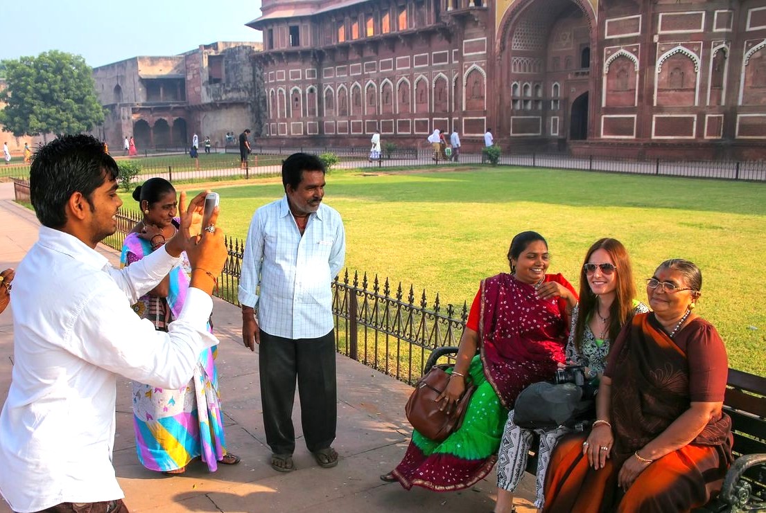 Group of tourists and local women posing before Agra Fort’s red sandstone heritage arches, showcasing India travel, cultural tourism, historic architecture, and travel photography Group of tourists and local women posing before Agra Fort’s red sandstone heritage arches, showcasing India travel, cultural tourism, historic architecture, and travel photography