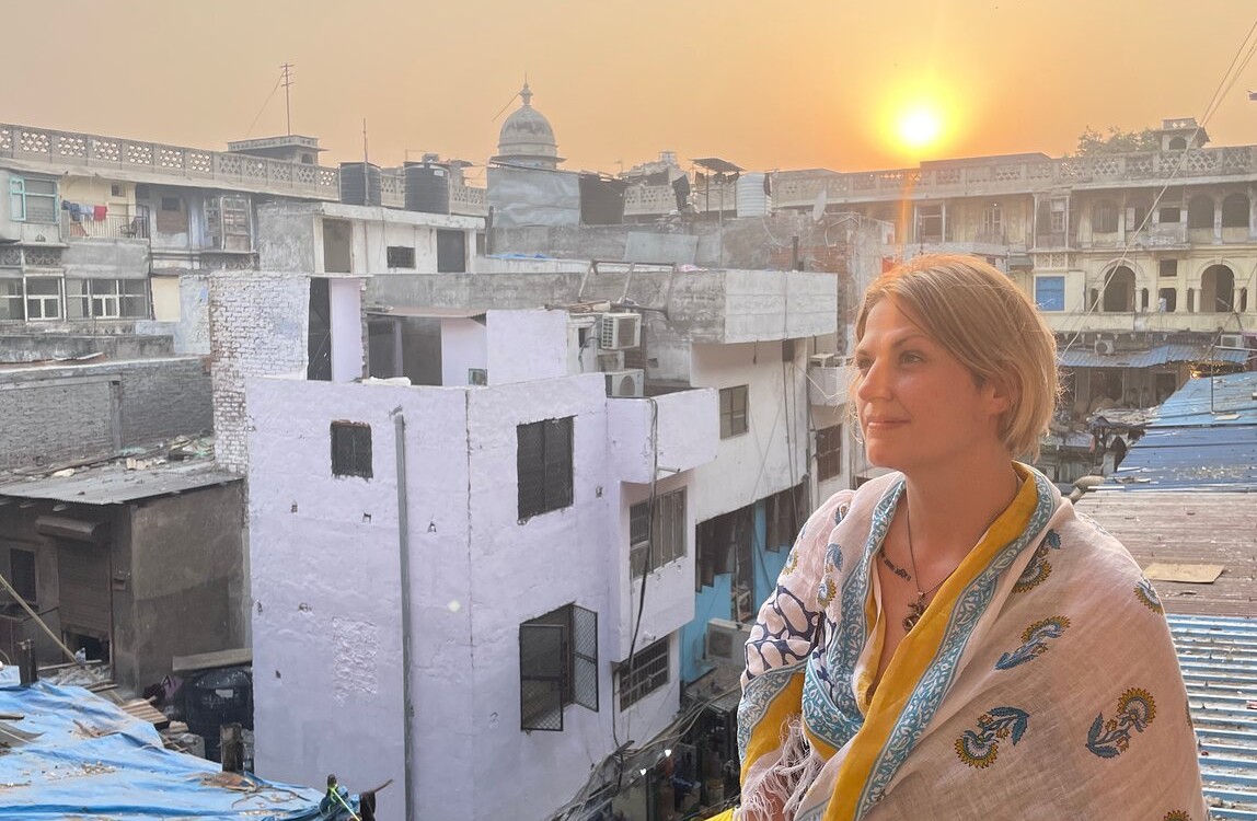 Golden sunset view from Chamundi Hill in Mysore, Karnataka, India showcases historic urban rooftops and reflective traveler’s silhouette blending cultural heritage and modern cityscape photography.