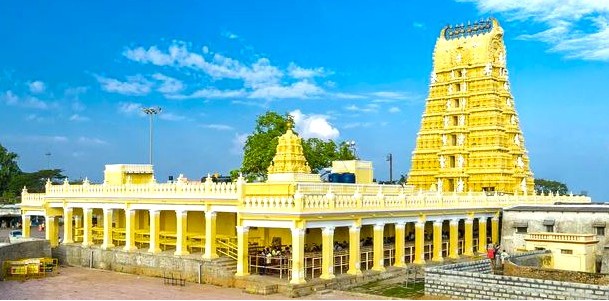 “Panoramic view of the historic Chamundi Hill Temple in Mysore, Karnataka, India showcasing a vibrant golden gopuram, traditional South Indian architecture, treasured sacred pilgrimage destination.”