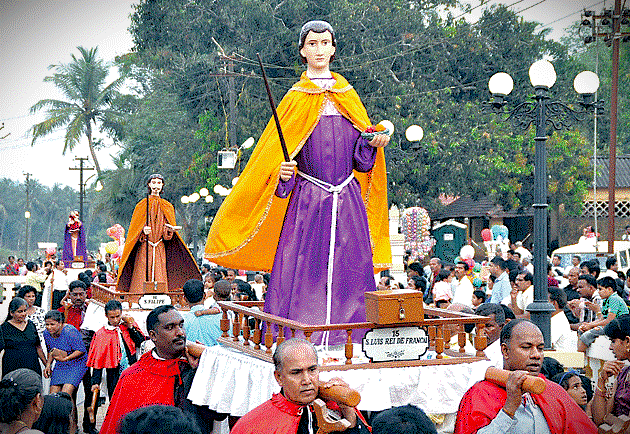 A vibrant religious festival procession in Goa, India, showcases local culture for tourists visiting UNESCO Old Goa sites like the Bom Jesus Basilica and Church of Our Lady of the Rosary, or nearby Anjua Beach Flea Market. A vibrant religious festival procession in Goa, India, showcases local culture for tourists visiting UNESCO Old Goa sites like the Bom Jesus Basilica and Church of Our Lady of the Rosary, or nearby Anjua Beach Flea Market.