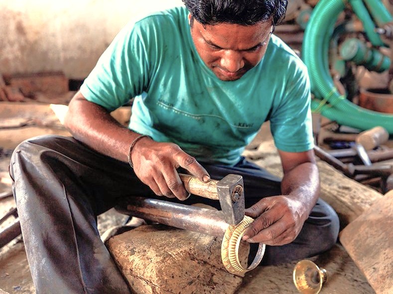 A skilled Indian artisan in Goa crafts traditional metalwork, a local artform tourists can find near Anjuna Beach Flea Market or while visiting UNESCO Old Goa sites like the Bom Jesus Basilica and Church of Our Lady of the Rosary. A skilled Indian artisan in Goa crafts traditional metalwork, a local artform tourists can find near Anjuna Beach Flea Market or while visiting UNESCO Old Goa sites like the Bom Jesus Basilica and Church of Our Lady of the Rosary.
