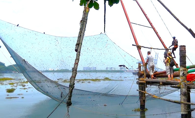 Tourists assist in operating iconic Chinese Fishing Nets along Kochi waterfront in South India, Kerala, capturing traditional maritime techniques, serene backwaters, cultural heritage and vibrant fishing community scenes at sunset. Tourists assist in operating iconic Chinese Fishing Nets along Kochi waterfront in South India, Kerala, capturing traditional maritime techniques, serene backwaters, cultural heritage and vibrant fishing community scenes at sunset.