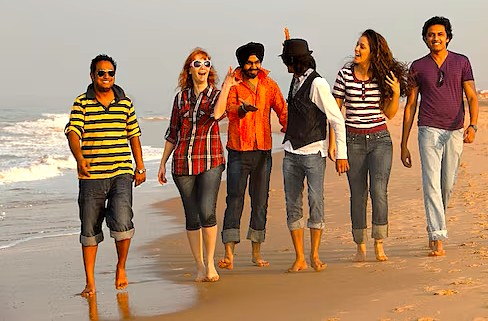 A group of diverse tourists enjoys walking on one of the famous beaches in Goa, India, a popular activity for visitors exploring Old Goa-Unesco churches like the Church of Saint Augustine. A group of diverse tourists enjoys walking on one of the famous beaches in Goa, India, a popular activity for visitors exploring Old Goa-Unesco churches like the Church of Saint Augustine.