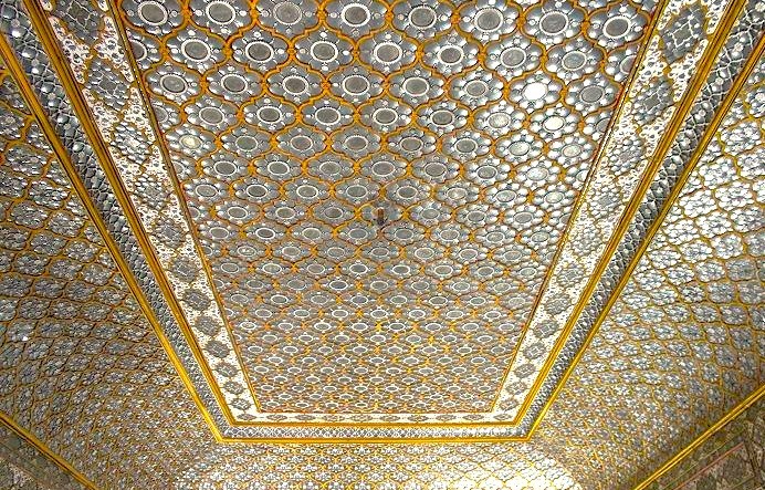 Beneath Jaipur’s UNESCO-listed Sheesh Mahal in Rajasthan, India, an opulent, magnificent mirrored ceiling dazzles with intricate geometric and floral patterns, reflecting royal craftsmanship and heritage in the City Palace interior.