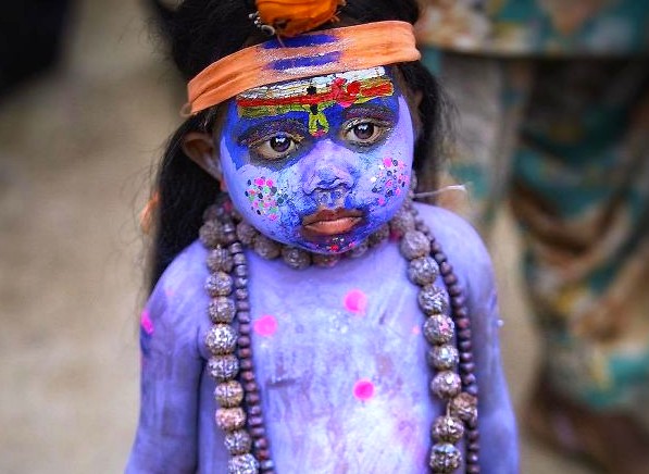 “Adorable child painted blue as Krishna during Holi festival near Clockwork Tower in Jodhpur, the Blue City of Rajasthan, India, wearing vibrant jewelry and orange headband, beaded necklace, smiling broadly.” “Adorable child painted blue as Krishna during Holi festival near Clockwork Tower in Jodhpur, the Blue City of Rajasthan, India, wearing vibrant jewelry and orange headband, beaded necklace, smiling broadly.”