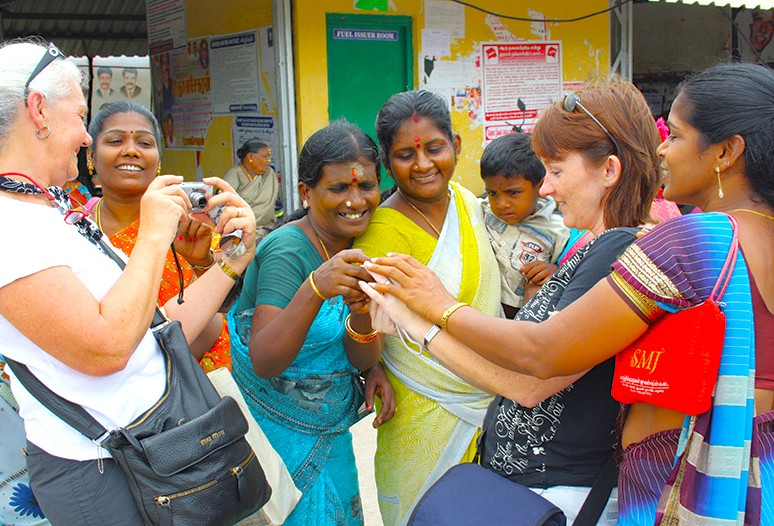 Local women interact with a foreign photographer at Coakers Walk in Kodaikanal’s Palani Hills, Tamil Nadu, South India, showcasing vibrant cultural exchange and community spirit.