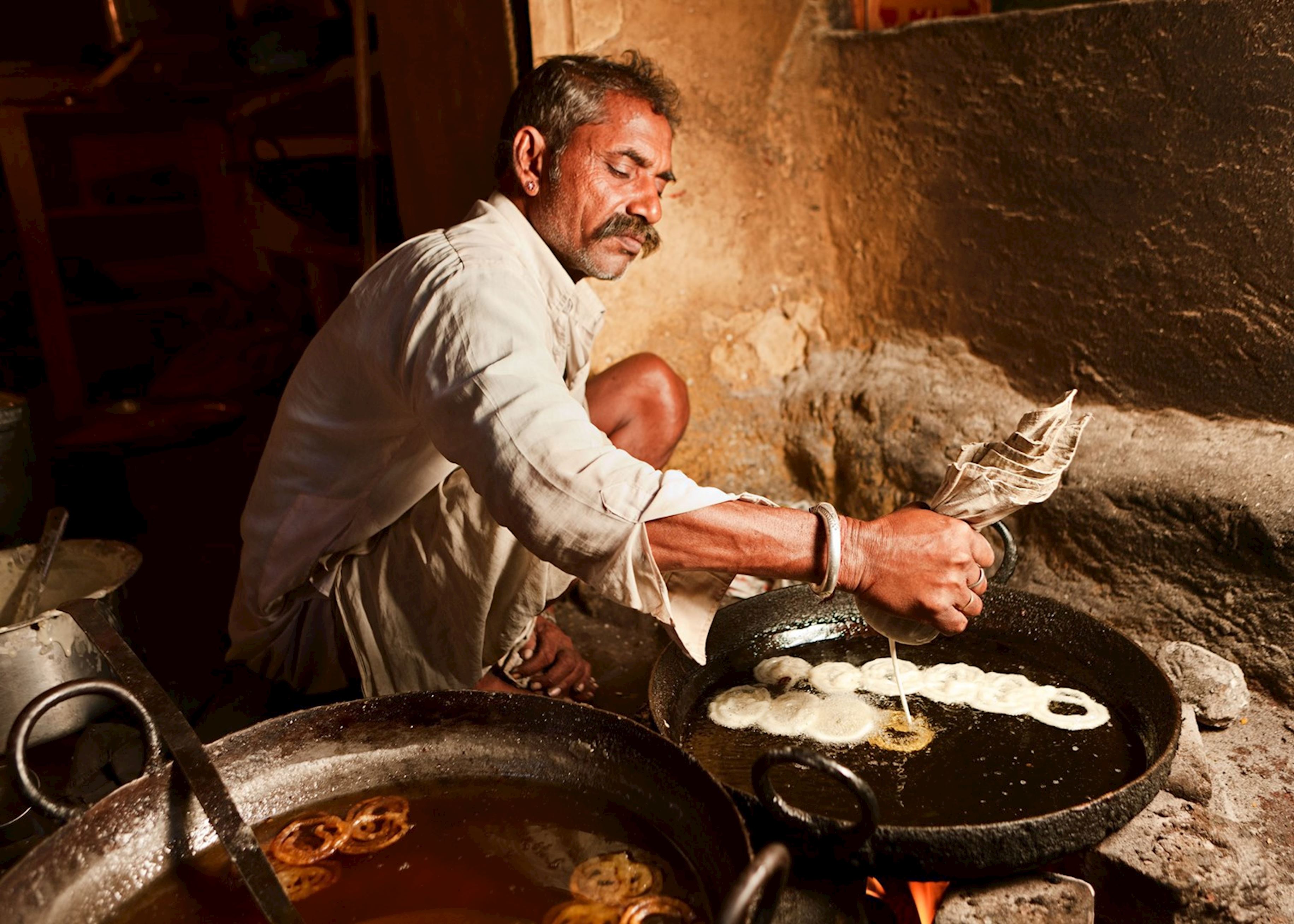 “Traditional street food vendor in rural Coimbatore, Tamil Nadu, India frying jalebi in a rustic earthen kitchen illustrating authentic vibrant South Indian local culinary heritage.”  “Traditional street food vendor in rural Coimbatore, Tamil Nadu, India frying jalebi in a rustic earthen kitchen illustrating authentic vibrant South Indian local culinary heritage.”