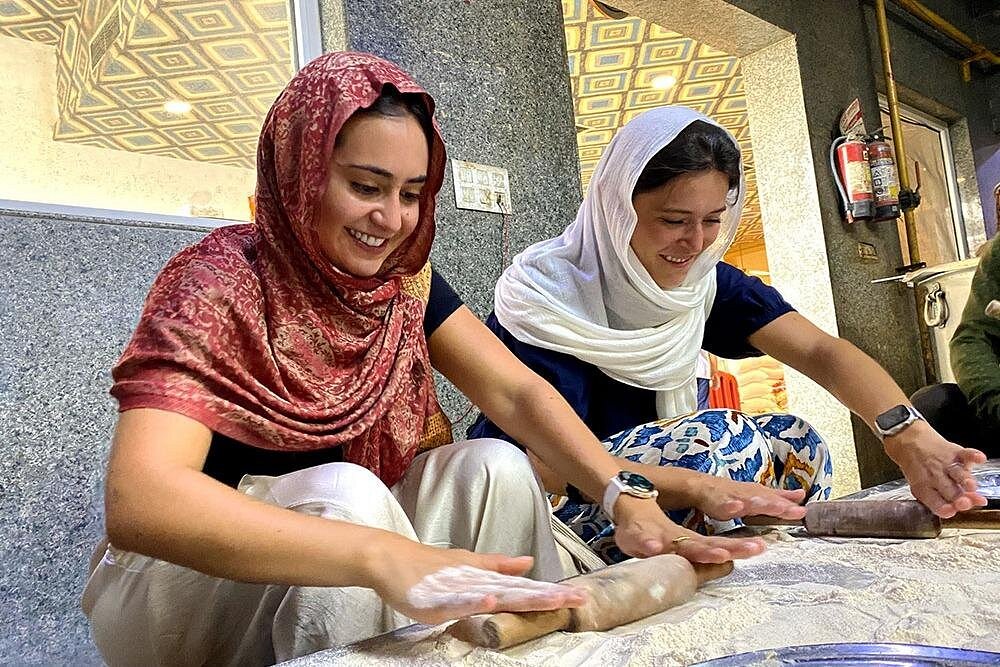 “Two women knead chapati dough at Coimbatore Tamil Nadu Town Hall Market in India, demonstrating authentic traditional cooking techniques and vibrant, rich local culinary heritage.” “Two women knead chapati dough at Coimbatore Tamil Nadu Town Hall Market in India, demonstrating authentic traditional cooking techniques and vibrant, rich local culinary heritage.”