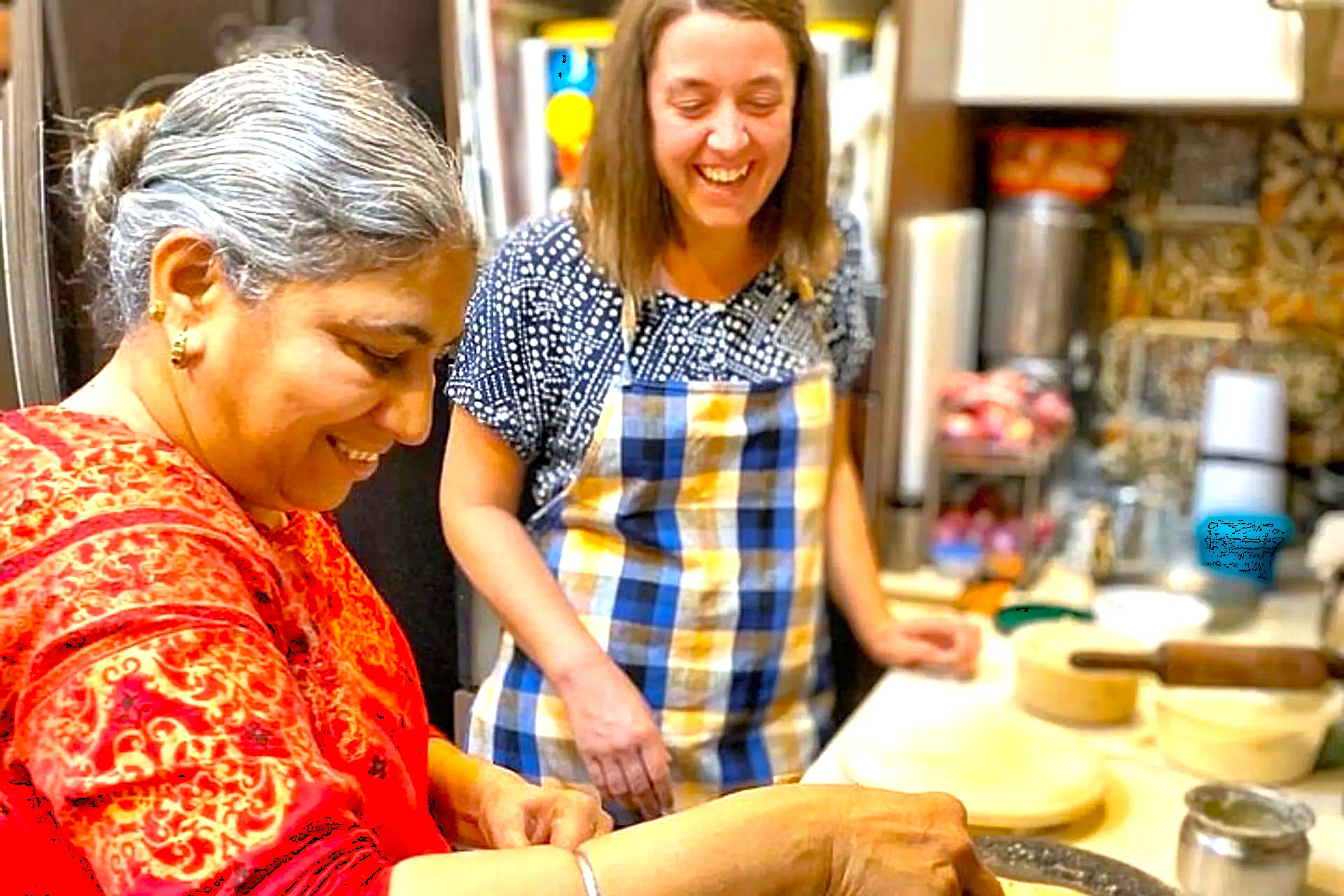 Two women enjoying cooking classes India in a traditional kitchen setting as expert instructor guides interactive, hands-on culinary lessons preparing authentic regional dishes with spices. Two women enjoying cooking classes India in a traditional kitchen setting as expert instructor guides interactive, hands-on culinary lessons preparing authentic regional dishes with spices.