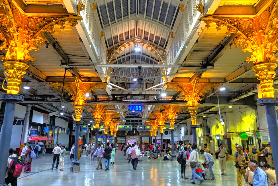 Vibrant interior of historic Chhatrapati Shivaji Maharaj terminus (CSMT) railway station in Mumbai, Mahapradesh, India, showcasing ornate golden pillars, vaulted ceilings, digital clocks, bustling crowds, and timeless colonial architectural grandeur. Vibrant interior of historic Chhatrapati Shivaji Maharaj terminus (CSMT) railway station in Mumbai, Mahapradesh, India, showcasing ornate golden pillars, vaulted ceilings, digital clocks, bustling crowds, and timeless colonial architectural grandeur.