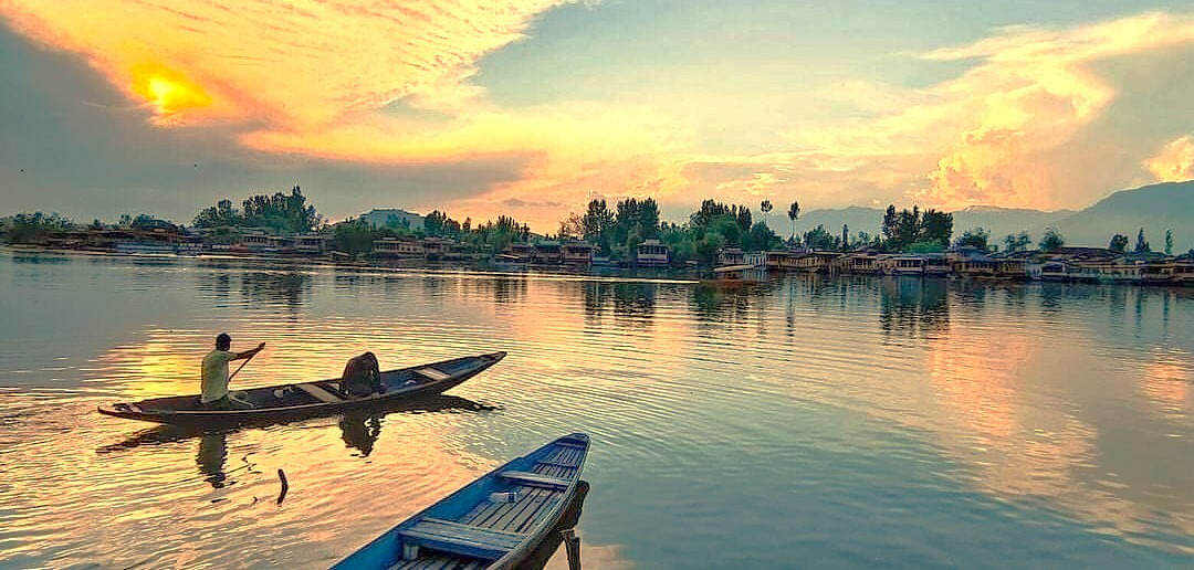 A stunning sunset over Dhal Lake in Srinagar, Jammu and Kashmir, home to a Light and Sound show and near saffron fields, Aru Valley, and Betaab Valley.