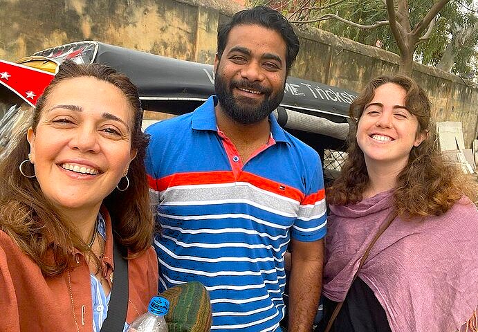Tourists smile with a local guide in Srinagar, Jammu and Kashmir, a city near Dhal Lake, the Light and Sound show, saffron fields, Aru Valley, and Betaab Valley.