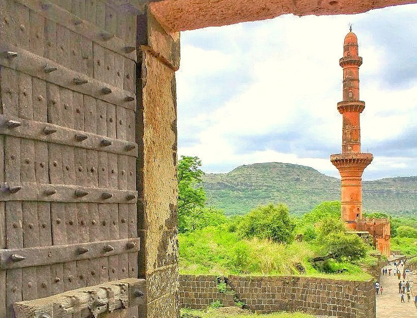 Stunning aerial view through Daulatabad Fort’s ancient wooden gate frames Aurangabad’s hills and UNESCO India heritage sites Ellora and Ajanta Caves in Maharashtra, showcasing centuries-old rock-cut architecture and cultural legacy.
