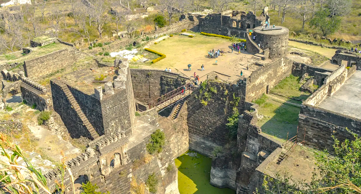 Aerial view of Daulatabad Fort in Aurangabad, Maharashtra, India, near UNESCO-listed Ajanta and Ellora Caves, showcasing ancient stone walls, heritage architecture, and lush surroundings for tourism enthusiasts and history buffs.