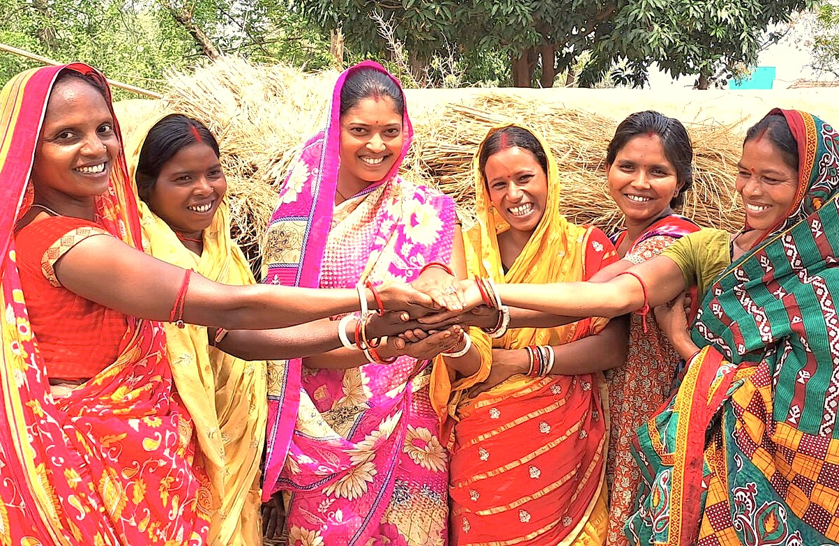 Vibrant group of local women in traditional sarees celebrating community unity near UNESCO-listed Ajanta and Ellora Caves in Aurangabad, Maharashtra, India, with historic Daulatabad Fort backdrop inspiring authentic heritage tourism.