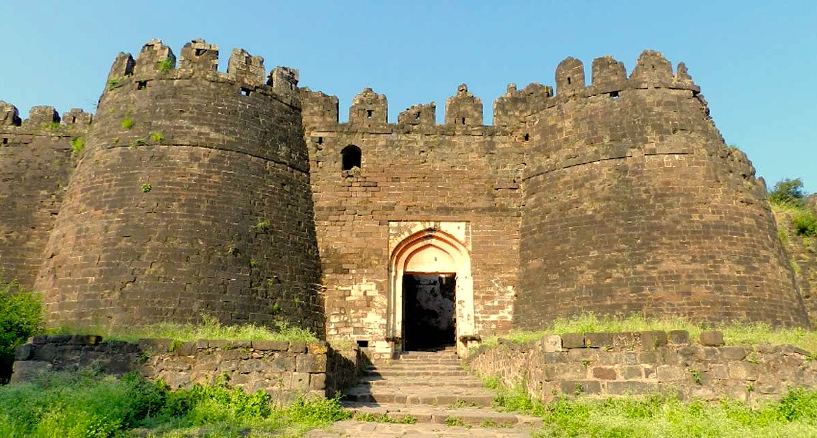 Panoramic aerial view of Daulatabad Fort in Aurangabad, Maharashtra, India, highlighting medieval bastions and ramparts against the backdrop of UNESCO-listed Ellora and Ajanta Caves, inviting cultural tourism and heritage exploration.