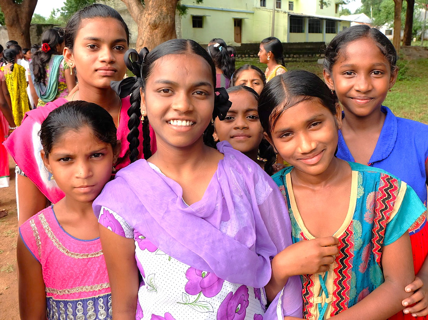 “Vibrant group of young Indian girls in traditional attire smile during a cultural gathering on the Deccan Plateau in Karnataka bordering the UNESCO Western Ghats, celebrating heritage, community, and education.”
