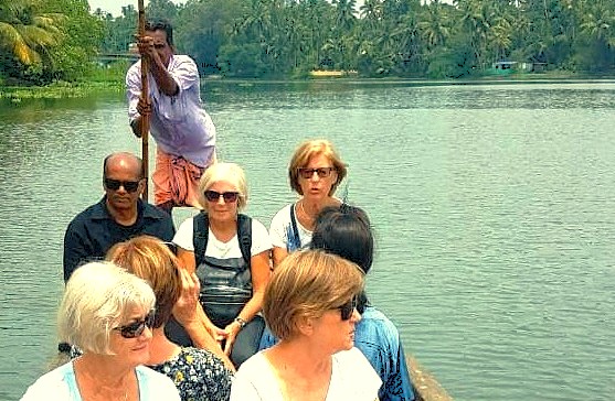  “A diverse group of tourists navigates a serene riverboat tour on the Deccan Plateau in Karnataka, India, bordering the UNESCO Western Ghats, showcasing lush greenery, cultural heritage, and natural beauty.”