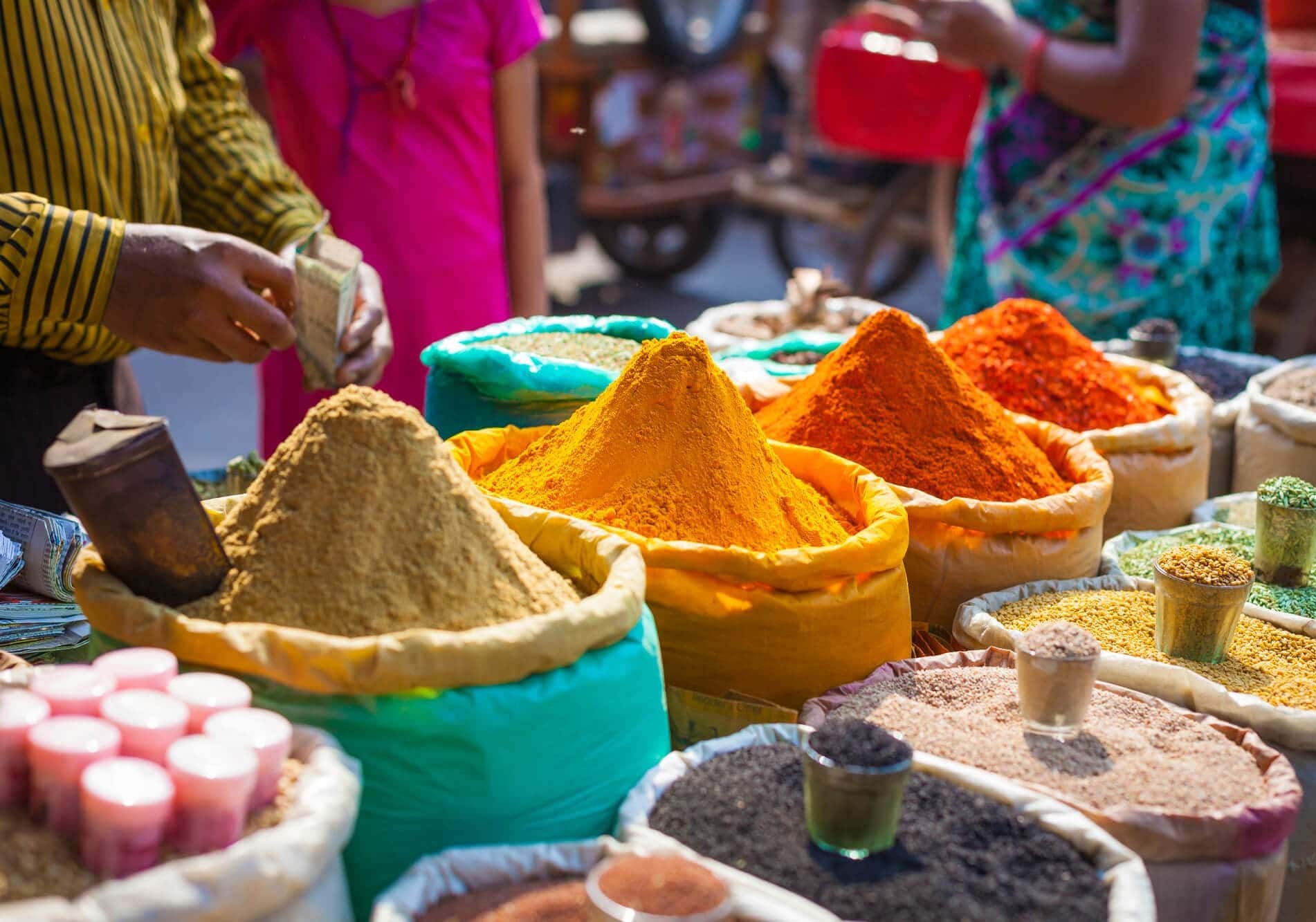 Vibrant spice stall in India-Chandni Chowk New Delhi bazaar displays turmeric, chili, cumin mounds in burlap sacks, bustling vendor exchanging cash, traditional market atmosphere with colorful spices, aromatic Indian ingredients. Vibrant spice stall in India-Chandni Chowk New Delhi bazaar displays turmeric, chili, cumin mounds in burlap sacks, bustling vendor exchanging cash, traditional market atmosphere with colorful spices, aromatic Indian ingredients.