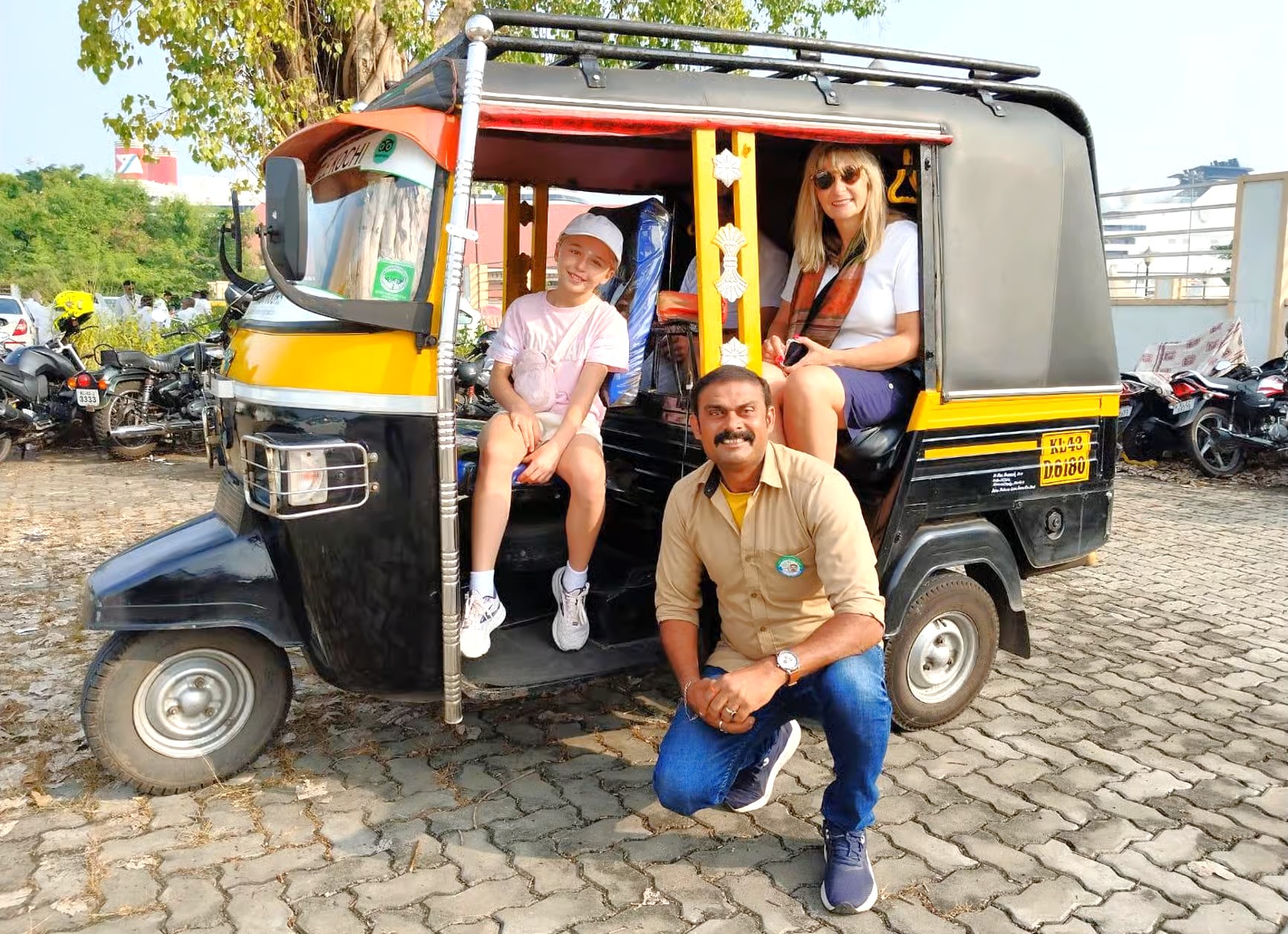Family smiles with local auto rickshaw driver amid bustling New Delhi streets, India-new Delhi, enjoying vibrant memorable cultural journey highlighting iconic transport, urban heritage, street exploration and authentic travel experience.