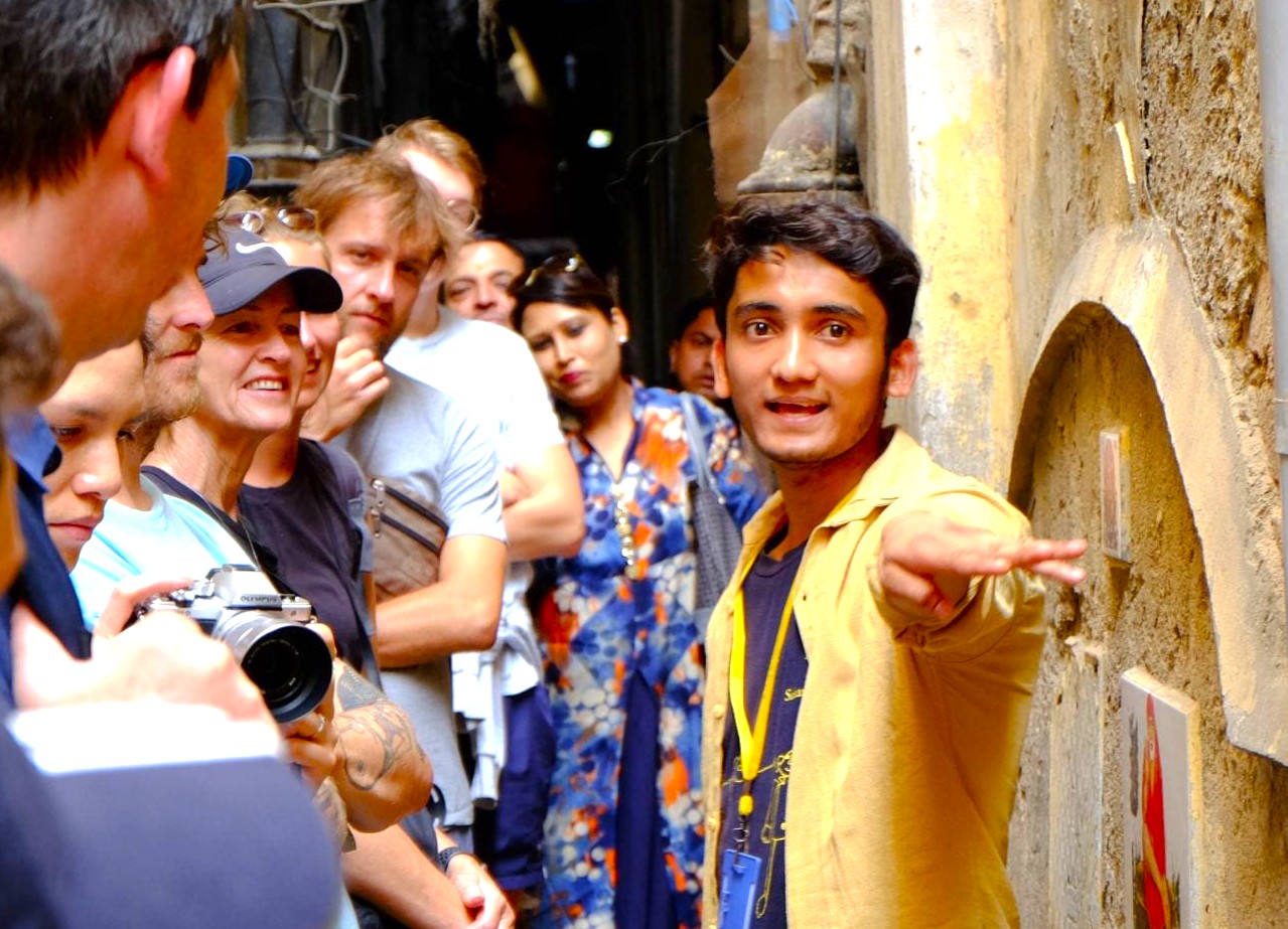 Tour guide wearing yellow lanyard leads diverse group of attentive travelers through a narrow heritage alley near India-Chandi Chowk Spice Market Old Delhi, capturing cultural insight, local history, immersive experience. Tour guide wearing yellow lanyard leads diverse group of attentive travelers through a narrow heritage alley near India-Chandi Chowk Spice Market Old Delhi, capturing cultural insight, local history, immersive experience.