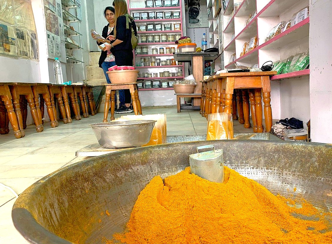 Turmeric and spice shop interior at Devaraja Market near Mysore Palace in Mysore near Bangalore, India showcases colorful powders, local herbs and bustling vendors, highlighting sensory appeal and cultural heritage.