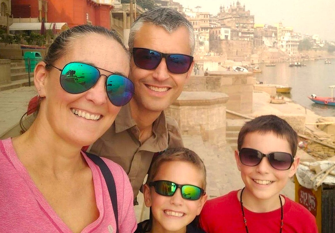  Happy family tourists smiling in Varanasi, India, near the famous Dasaswamedh Ghat on the Ganges River, close to the Sarnath UNESCO World Heritage Site.
