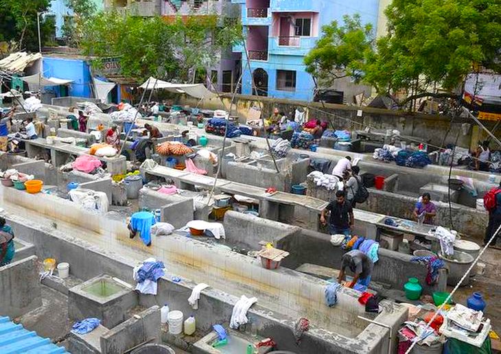 Vibrant outdoor Dhoby Khana laundry ghat in Kochi, Kerala, South India showcases traditional centuries-old communal washing basins, skilled launderers, colorful clothes hanging, and urban heritage bathing culture by the waterfront. Vibrant outdoor Dhoby Khana laundry ghat in Kochi, Kerala, South India showcases traditional centuries-old communal washing basins, skilled launderers, colorful clothes hanging, and urban heritage bathing culture by the waterfront.