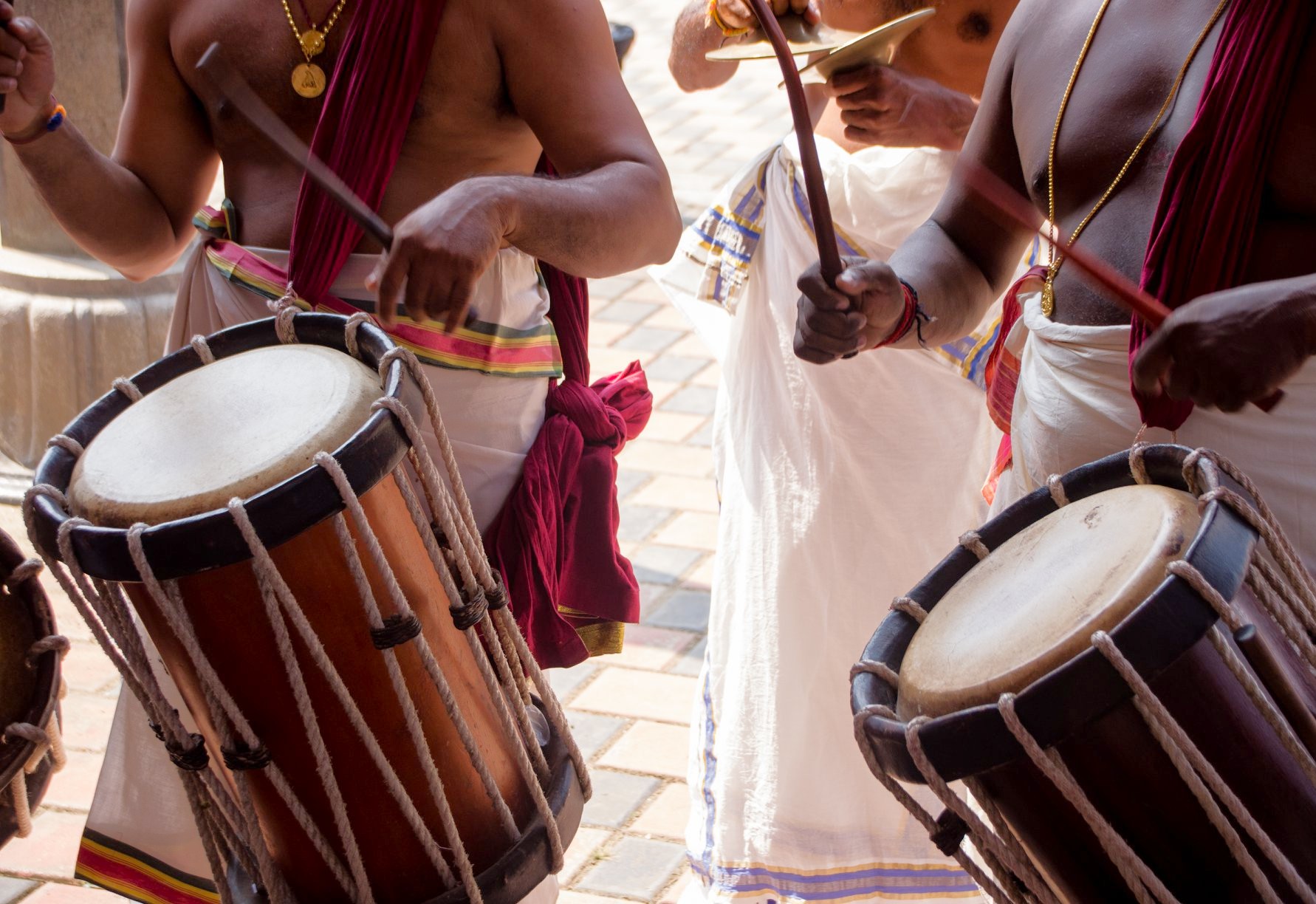 Vibrant festival scene featuring traditional drummers performing energetically at the historic Kochi Dhoby Khana Laundry grounds in Kerala, South India, showcasing cultural attire, rhythmic drums, colorful sarongs, and outdoor celebration. Vibrant festival scene featuring traditional drummers performing energetically at the historic Kochi Dhoby Khana Laundry grounds in Kerala, South India, showcasing cultural attire, rhythmic drums, colorful sarongs, and outdoor celebration.